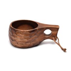 a wooden bowl with a handle on the side and an empty spoon in front of it