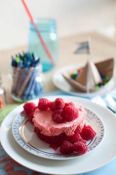 raspberry cheesecake on a plate with colored crayons in the background