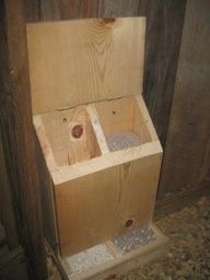 a wooden box sitting on top of a floor next to a wood wall with holes in it