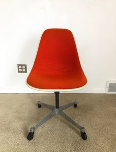 an orange chair sitting on top of a carpeted floor