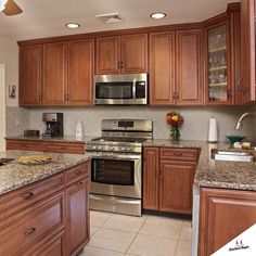 a kitchen with granite counter tops and wooden cabinets, along with stainless steel appliances in the center