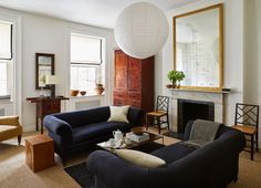 a living room filled with furniture and a fire place under a large light fixture over a fireplace