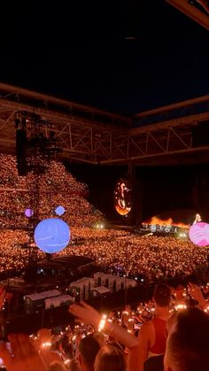 a large group of people at a concert with lights on the stage and in front of them