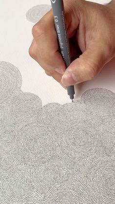 a hand holding a marker writing on an apple wallpaper with white and gray circles