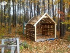 a shed made out of wood in the woods