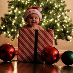 a baby wearing a santa hat sitting in a christmas present