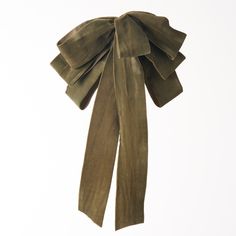 an olive green bow tie hanging on a white wall