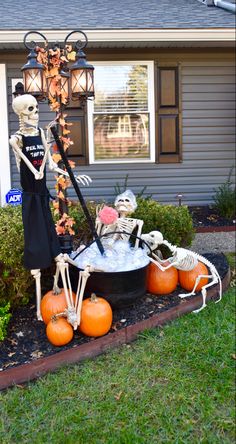 halloween decorations in front of a house with skeletons and pumpkins on the ground outside