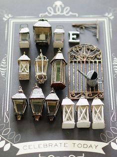 a collection of miniature lanterns and lights on a black table with an ornate border around it