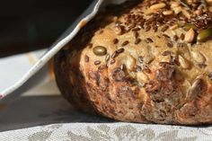 a loaf of bread sitting on top of a table covered in nuts and raisins