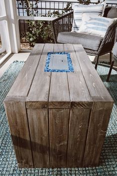 a wooden table sitting on top of a blue rug in front of a patio door