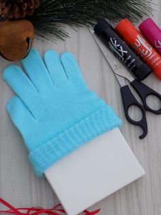 a pair of blue gloves sitting on top of a table next to scissors and markers