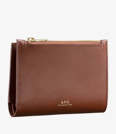 A.P.C. Women's coin purse. - Smooth calfskin leather.- Rounded corners.- Vegetable tanning, will develop a natural patina.- Eight-position cardholder, four on right and four on left.- One banknote pocket.- Snap button closure.- Zipped pocket.- Goldtone 'A.P.C. rue Madame' logo embossed on front. Topstitched edges. Brown Luxury Coin Purse With Card Slots, Luxury Brown Coin Purse With Card Slots, Classic Brown Business Coin Purse, Formal Brown Coin Purse With Interior Card Slots, Formal Brown Coin Purse With Card Slots, Luxury Brown Bifold Coin Purse, Faux Leather Bag, Exclusive Clothing, Backpack Tote Bag