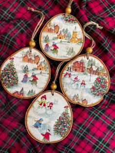 three christmas ornaments are hanging on a red and black plaid cloth with gold trimmings