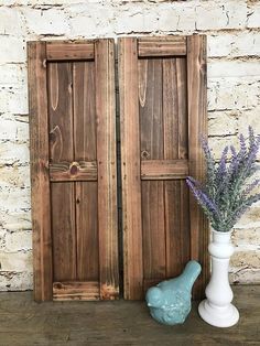 two vases with flowers in front of wooden doors