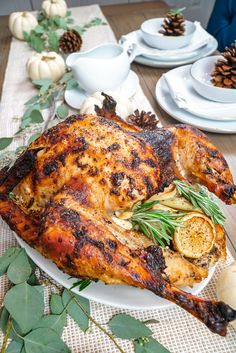 a roasted turkey on a white plate with herbs