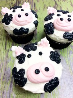 three cupcakes with black and pink frosting on top of each one in the shape of a cow