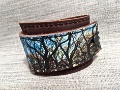 "This item is authentically handmade of genuine leather, the front has a photo digital image printed directly onto leather, produced in my studio. I've made this wrapping cuff out of soft leather, choose a black or brown base. Machine stitched, it has an attached elastic that hooks over a button, so this cuff will adjust to fit most wrist sizes 5.75\" to 7\" in circumference. At the narrowest, the width of the cuff is 1.25\" and at the widest it's 2\". Only premium quality leather and supplies a Tree Lover, Bracelet Leather, Leather Wrap Bracelet, Leather Cuffs, Leather Wraps, Photo Print, Tangled, Digital Image, Print Images