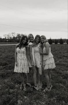 three girls are standing together in a field