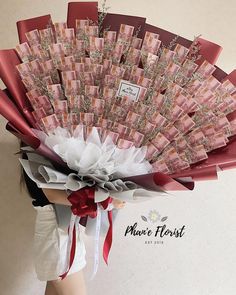 a woman is holding a bouquet made out of money