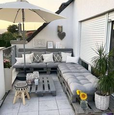 an outdoor living area with couches, tables and umbrellas on the roof terrace