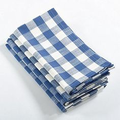 four blue and white checkered napkins stacked on top of each other