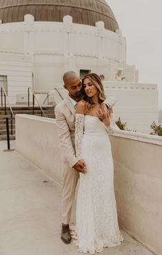 a bride and groom pose for a photo in front of the dome