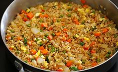 a pan filled with rice and vegetables on top of a stove