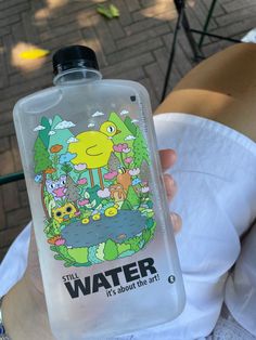 a person holding up a water bottle with an image of a cartoon character on it