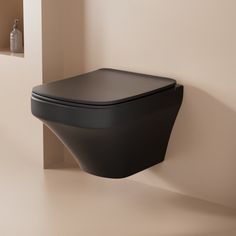 a black toilet sitting next to a white wall