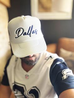 Dallas Hat, D-Town Trucker Hat, Texas Hat, Big D Hat, Cowboy Hat, Football Hat, Gift For Her, White/Navy  Embroidered Foam Trucker Hat Stand out from the crowd with this trendy foam trucker hat! This head accessory is made with high-quality polyester and foam that guarantees a premium look and feel. The foam trucker hat has an adjustable snap that ensures a comfortable fit, and the mesh back provides great breathability. The matching color braid gives the hat an extra oomph. Style it with your f White Cotton Trucker Snapback Hat, White Trucker Hat With Letter Print And Flat Brim, White Trucker Hat With Letter Print, White 5-panel Baseball Cap For Baseball Season, White Hip Hop Hat For Baseball Season, White Curved Brim Trucker Hat, White Baseball Hat With Embroidered Logo, White Curved Brim Hat For Baseball Season, White Letter Print Dad Hat For Baseball Season