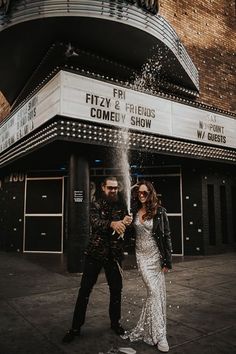 a man and woman standing in front of a movie theater