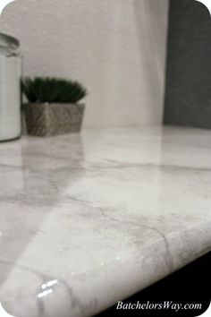 a marble counter top next to a plant in a vase