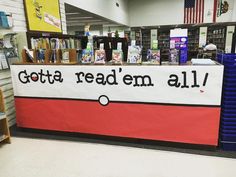 a sign that reads gota read'em all in front of some bookshelves