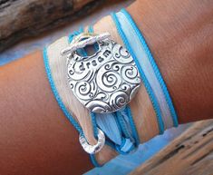 a close up of a person's arm wearing a bracelet with an elephant on it