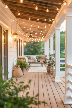 an outdoor covered porch with string lights and potted plants