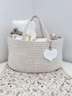 a baby basket sitting on top of a table next to a white pillow and blanket