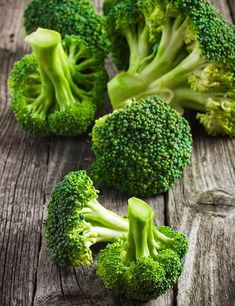 several pieces of broccoli on a wooden table