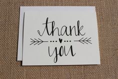 a thank card with an arrow and the words thank you written in cursive ink