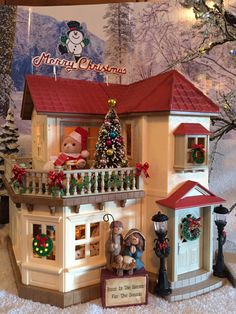 a doll house with christmas decorations on the balcony