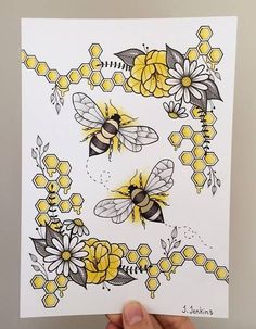 a hand holding up a card with bees and flowers on it