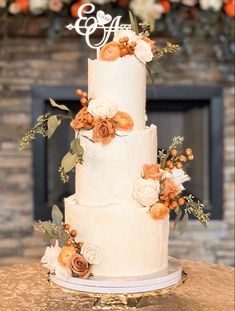 a white wedding cake with orange flowers on top