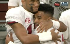 two men hugging each other in front of fans