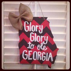 a sign that says glory is to be georgia with a bow on the front door