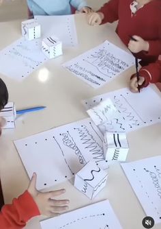 two children sitting at a table with paper cut out to spell out letters and numbers