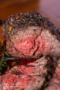 some meat is sitting on a plate with herbs