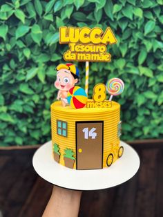 a birthday cake that is shaped like a school bus with a cartoon character on top