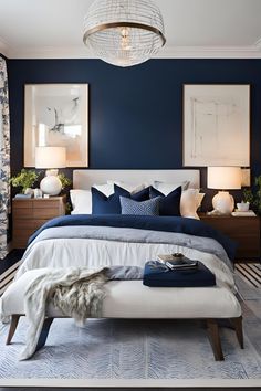 a bedroom with blue walls, white bedding and two pictures on the wall above it