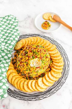 a plate full of crackers and a bowl with dip in it on a table