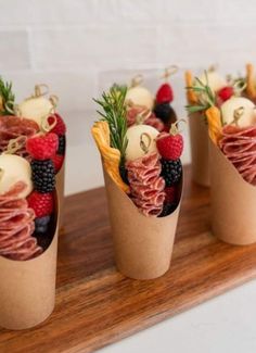 four small cups filled with food on top of a wooden tray next to each other